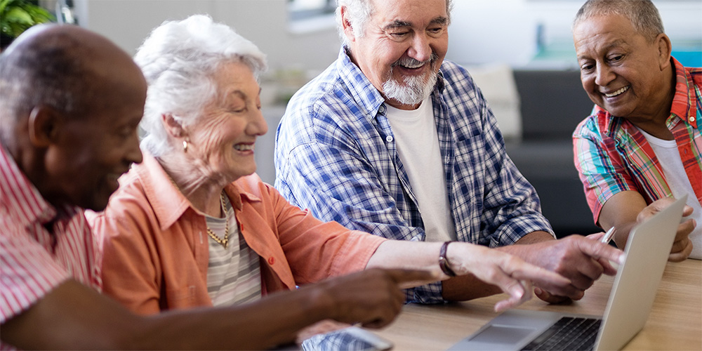 Group of older learners exploring a laptop