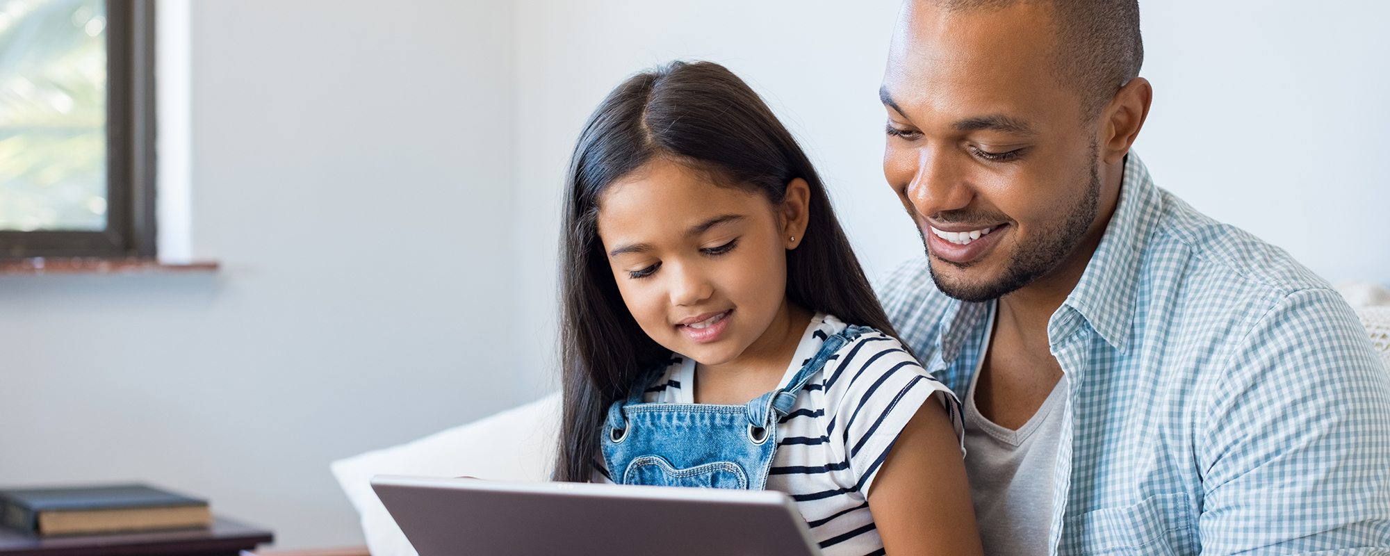 man and young girl watching a tablet together | Digital Wings blog | What is streaming