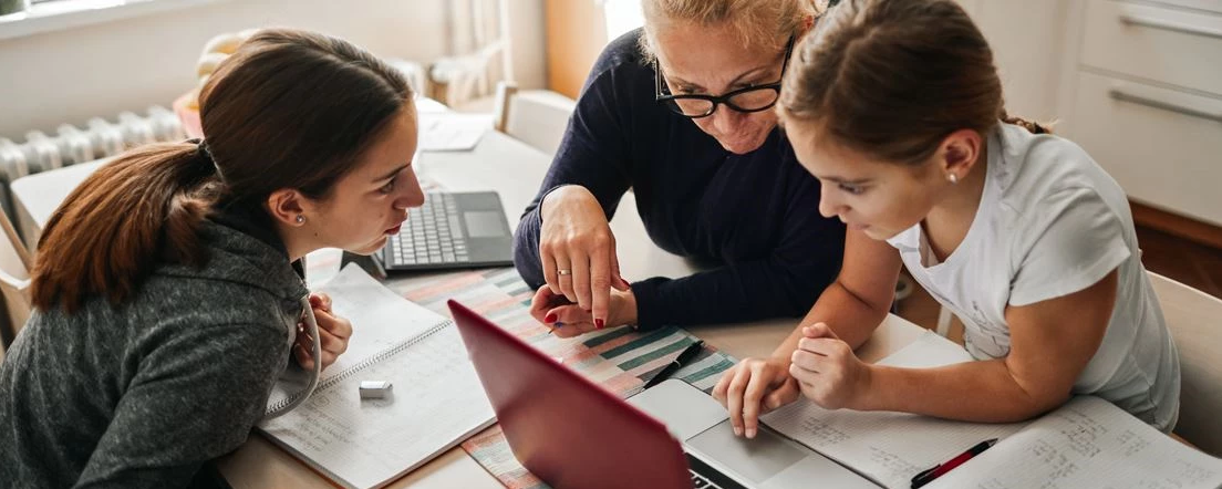 parent and children looking at a laptop together