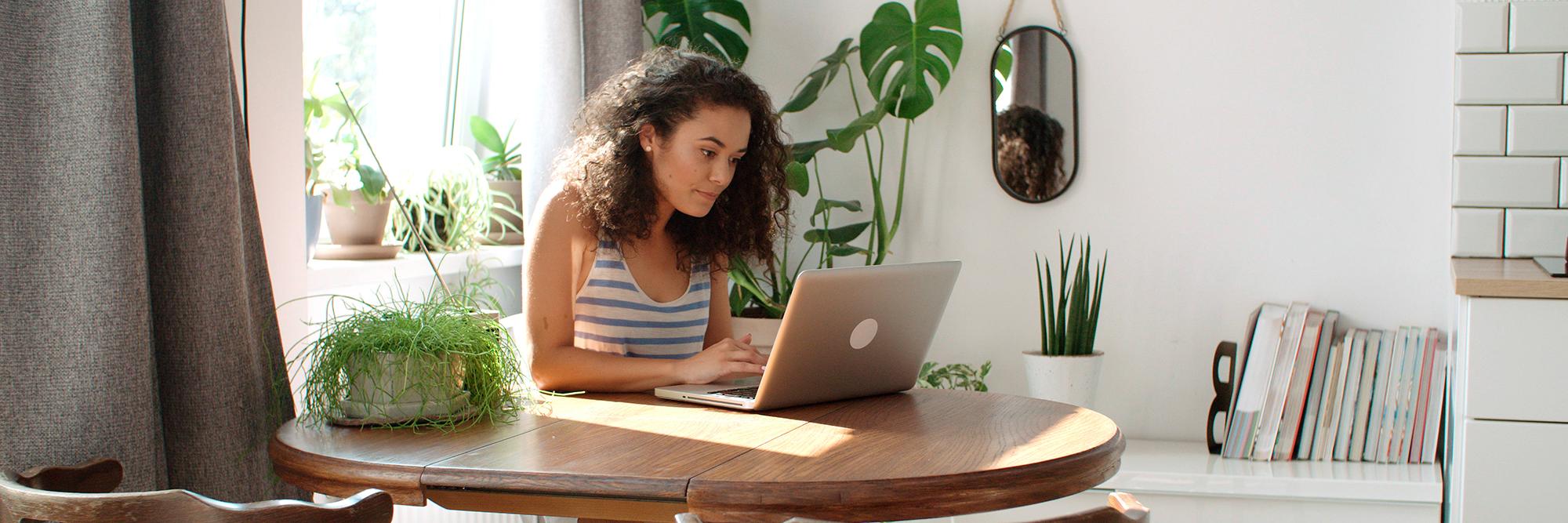 woman sitting at a table concentrating at her computer | Beginner's guide to using email