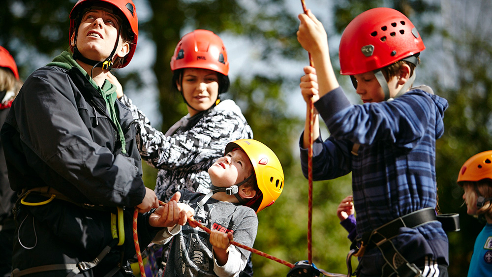 Cub scout leader helping with harness