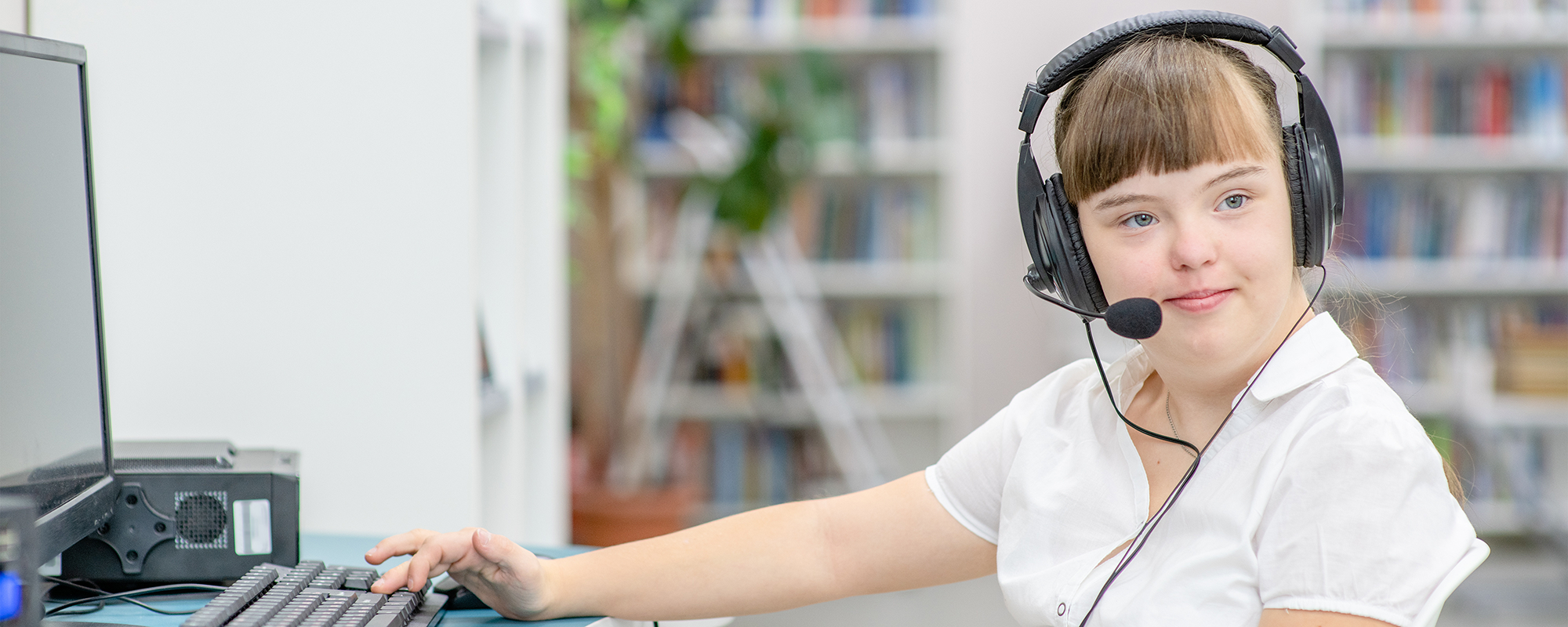 girl wearing a headset using a computer