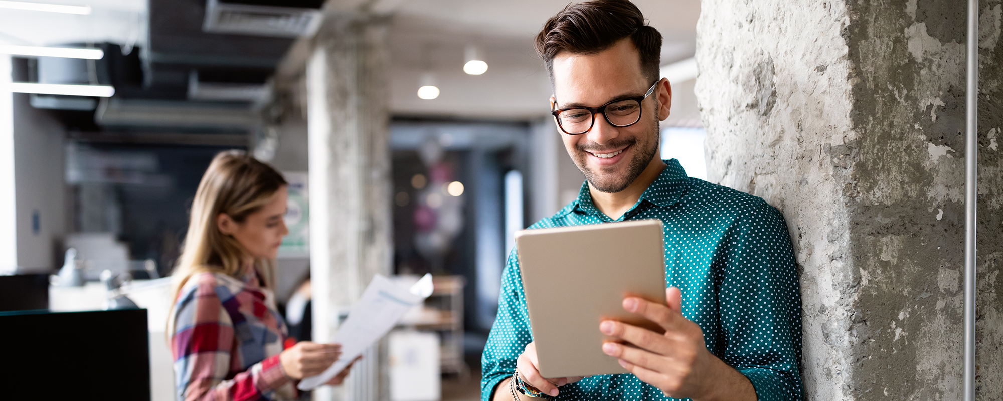 Man holiding a tablet and smiling | digital wings social media for small businesses