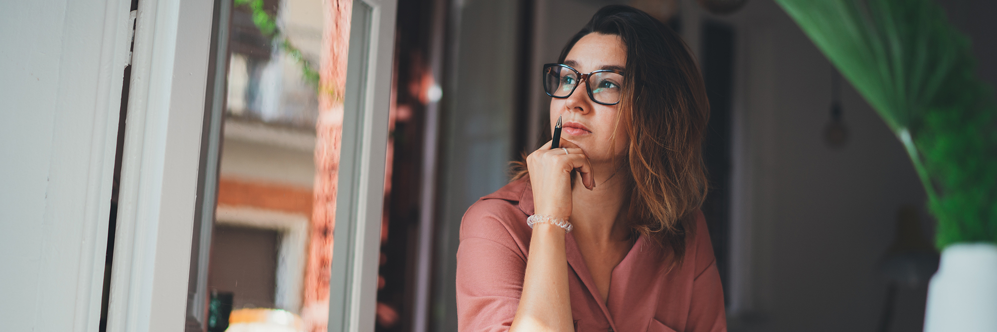 Woman looking away from her computer looking thoughtful | How to stay focused when WFH