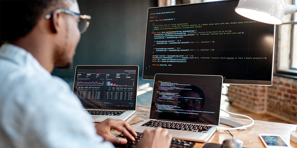 Developer working on multiple screens of code