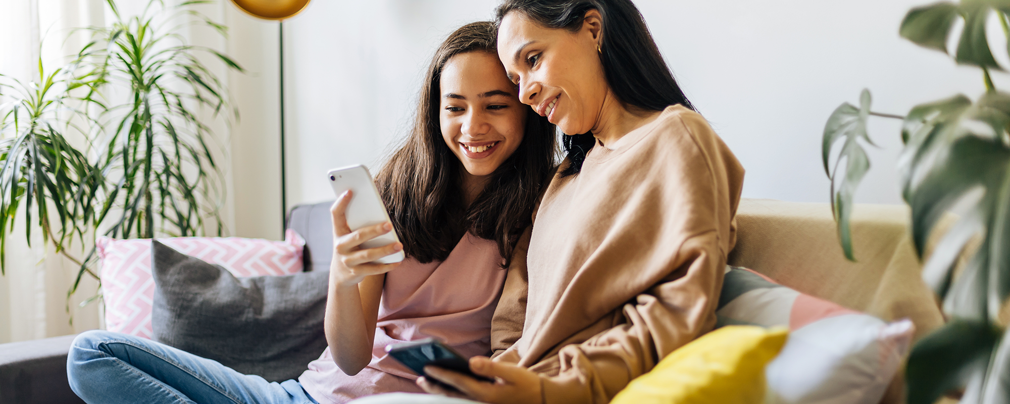 Mother and daughter looking at a smartphone together.