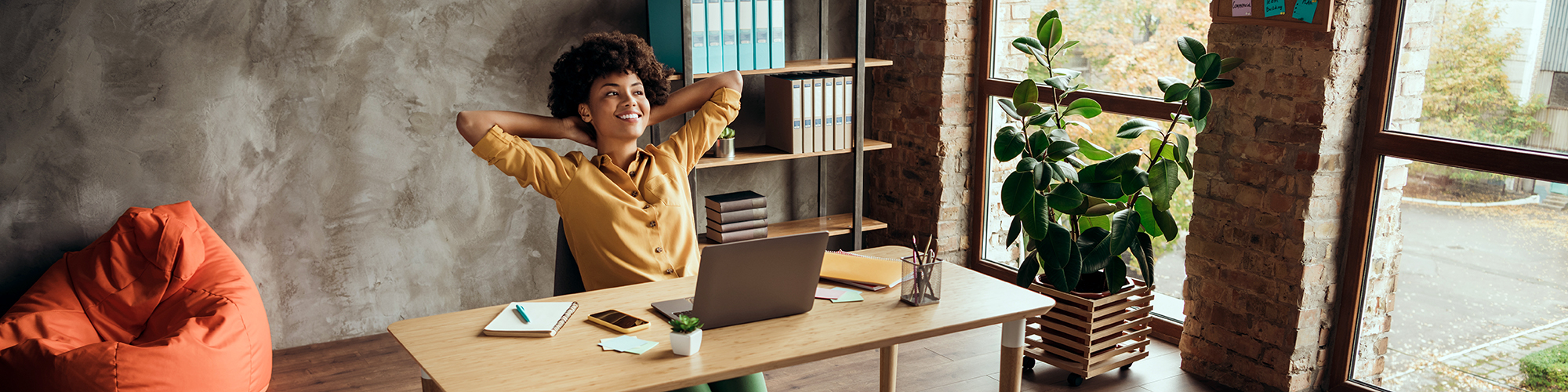 Lady with arms folded behind his head leaning back from a desk | Getting started with the internet course | Digital Wings