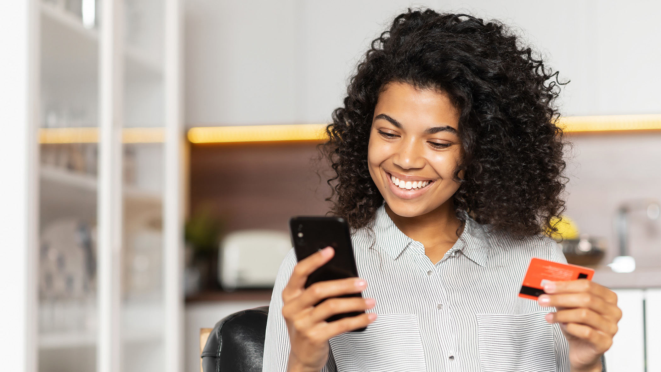 Person holding a phone and a bank card