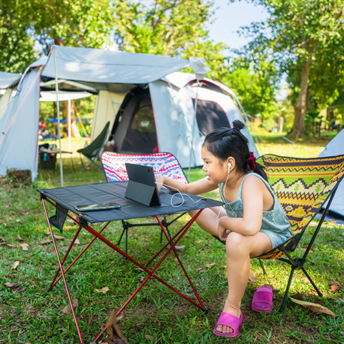 Child watching a film whilst relaxing on a camping holiday