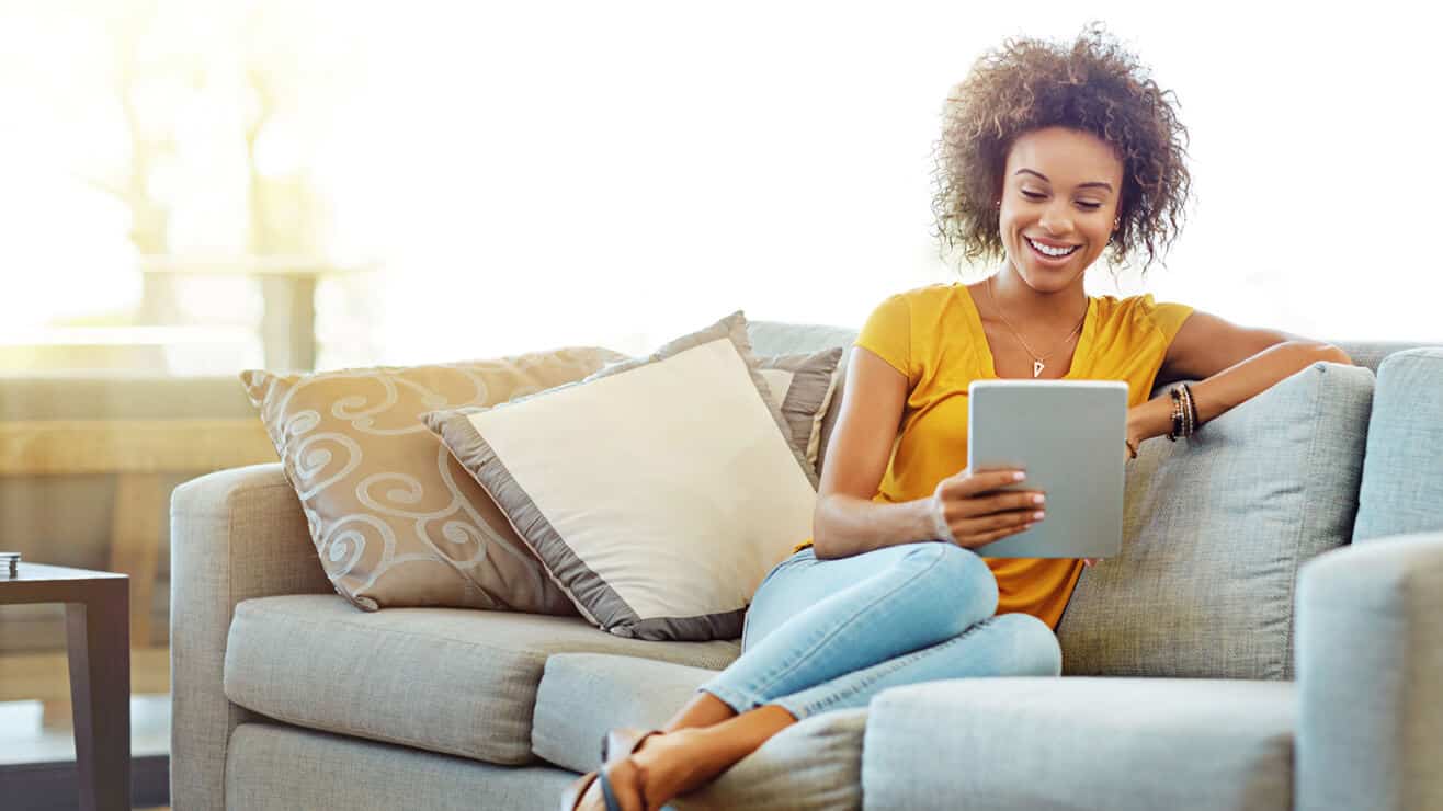 woman on a sofa looking at a tablet