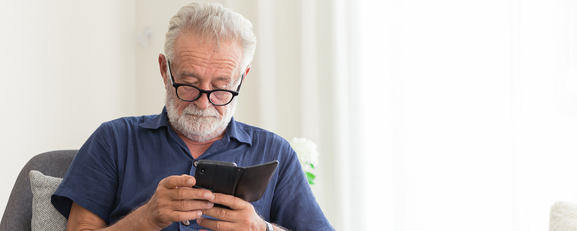 older man looking at his smart phone | Beginner's guide to using email