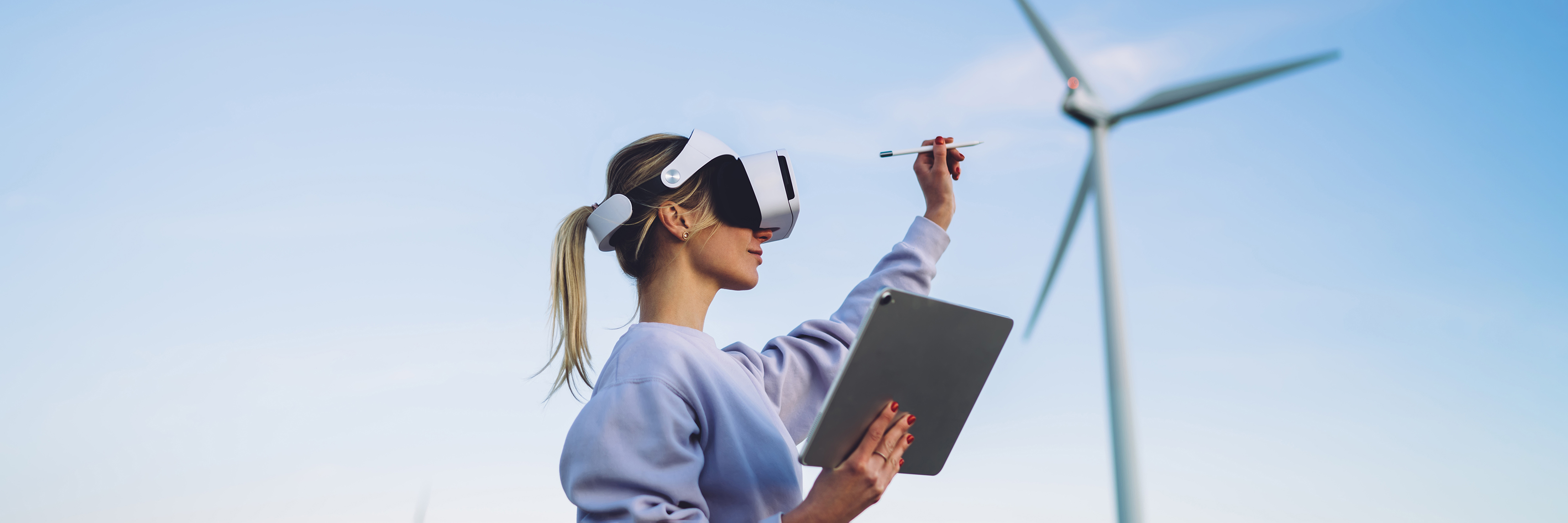 woman wearing vr headset with ipad in hand waving smart pen around