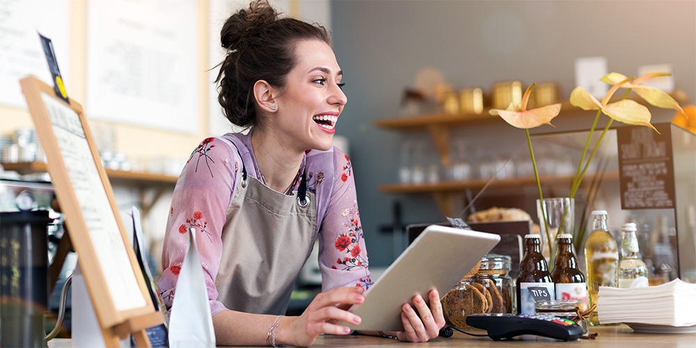 Business owner smiling while holding a tablet