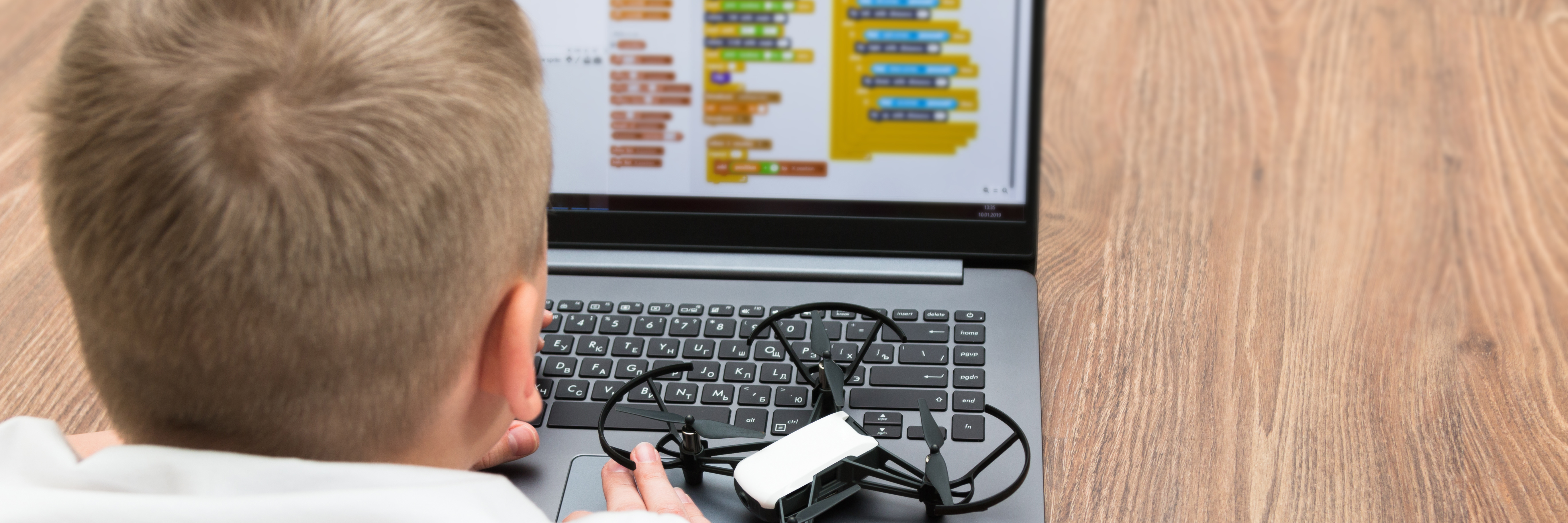 child using scratch om a laptop with a drone