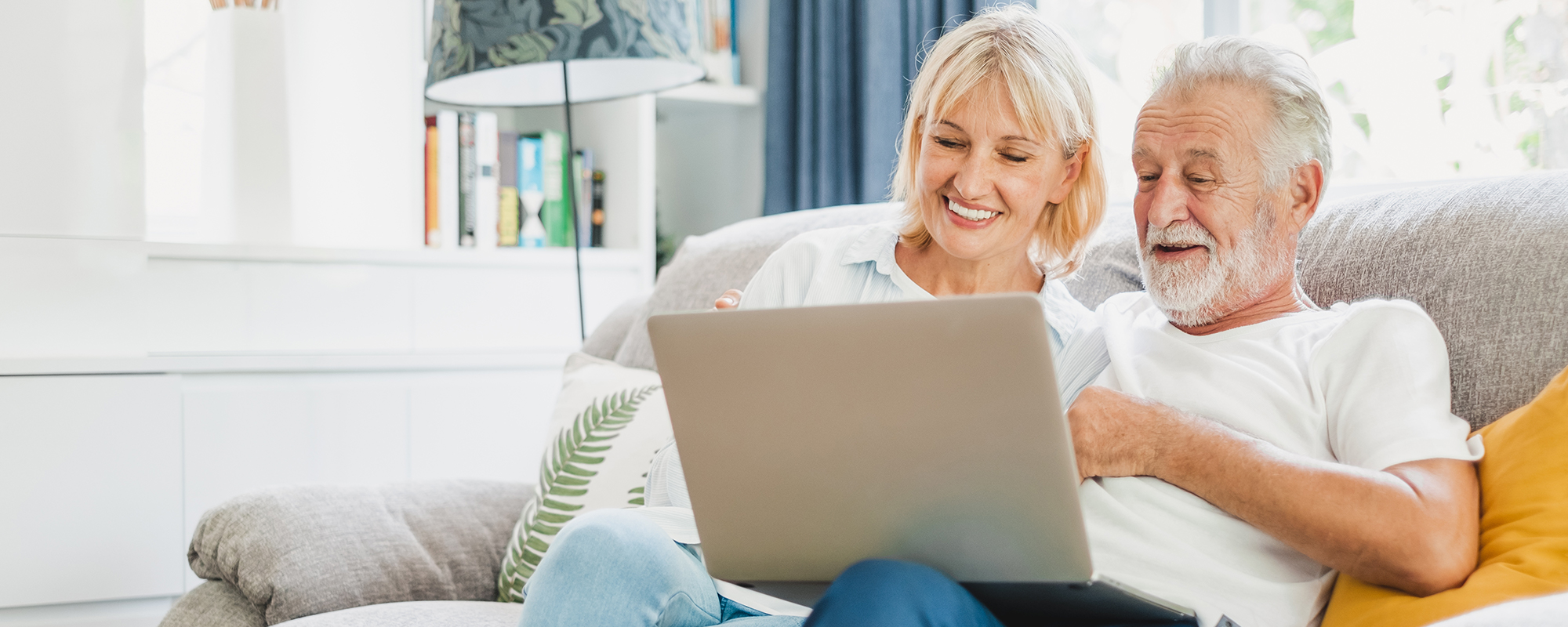 older man and woman smiling looking at a laptop | Beginner's guide to using email