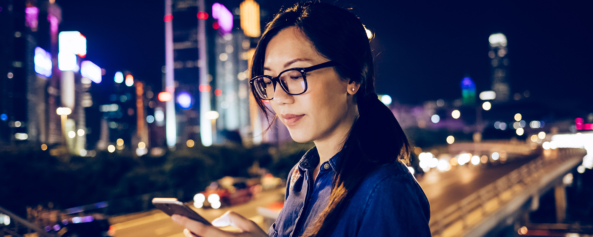 woman looking at her phone outside at nighttime