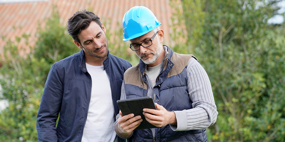 Builder talking to homeowner, showing result on tablet