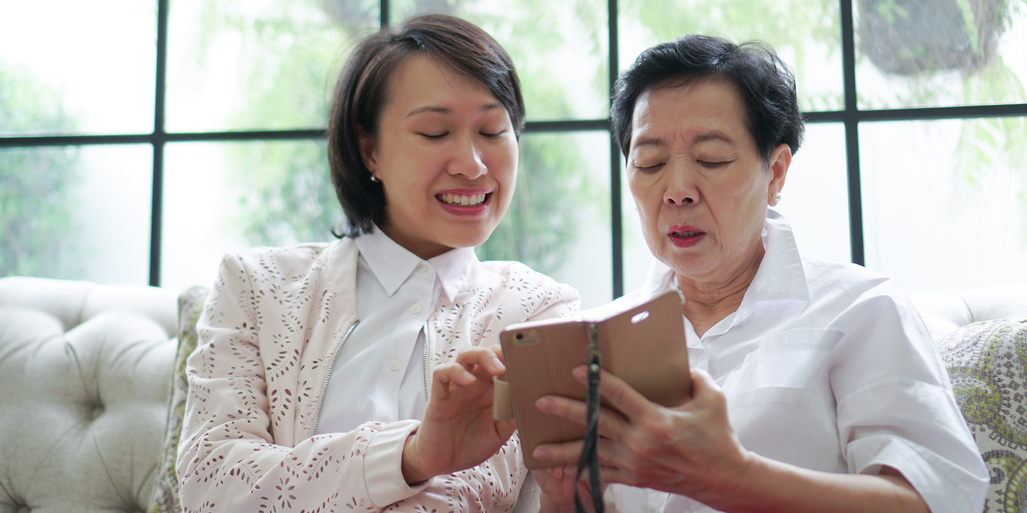 older lady and a young lady looking at a smartphone together  | smartphone for a grandparent