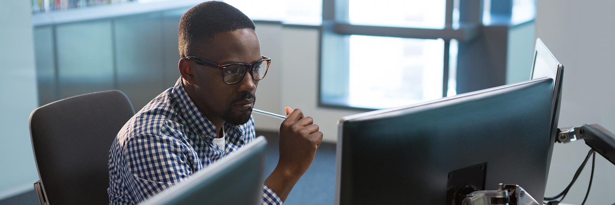 man looking very serious at two computer screens | Digital Wings | Online money management