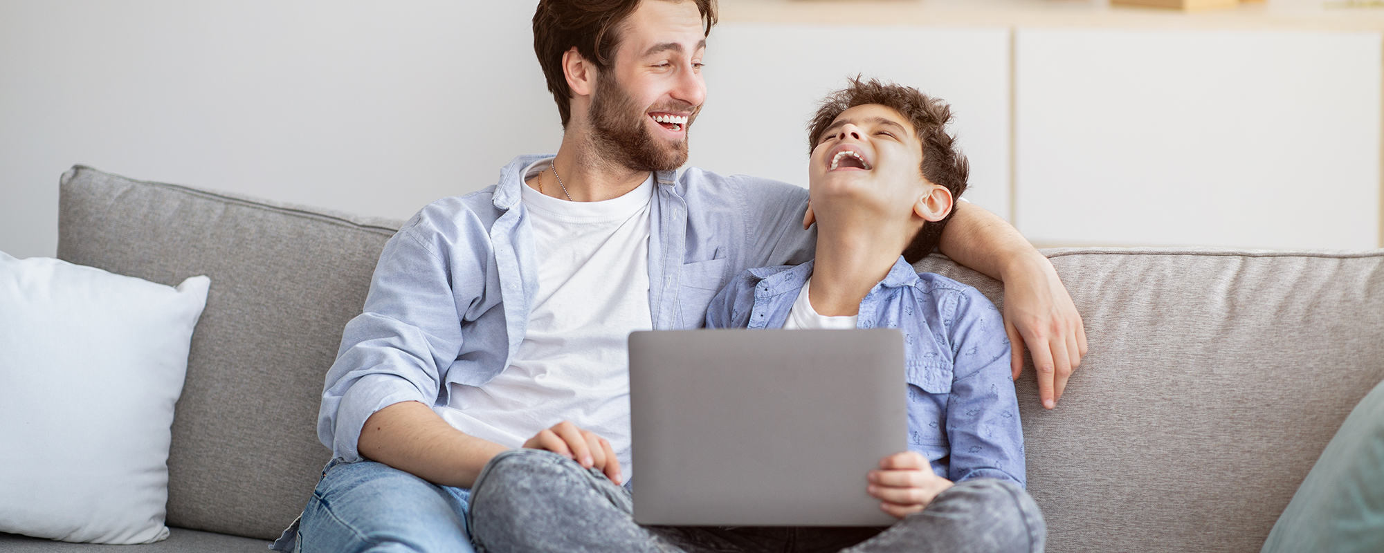 fater and son looking at a computer and laughing