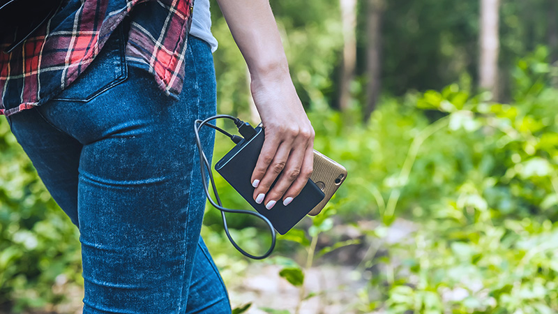 Person charging their phone while walking