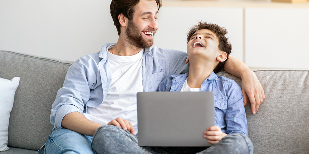 Father and son laughing at something they found online