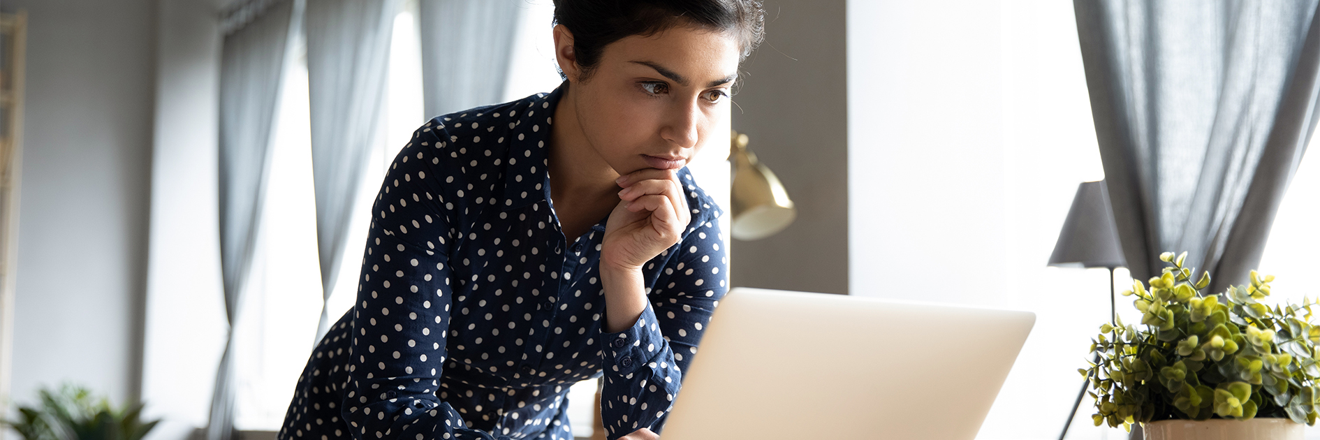 Person looking at laptop concerned.