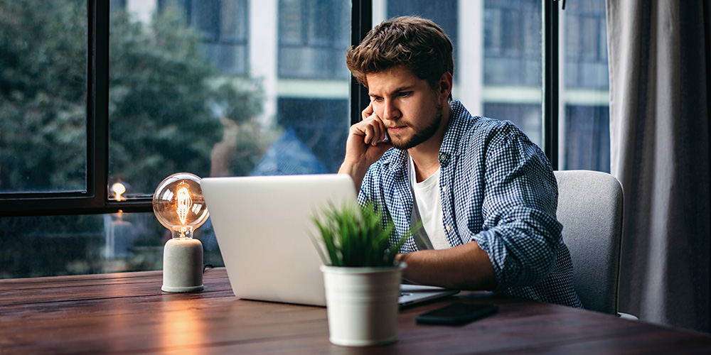 Man looking puzzled at his laptop